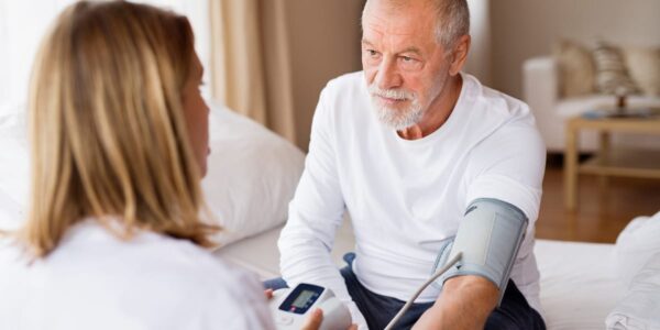 nurse taking a patient's blood pressure in a home setting