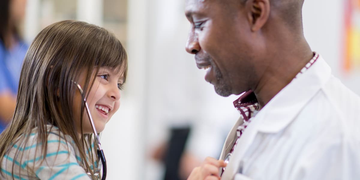 girl using stethoscope to listen to a doctor's chest