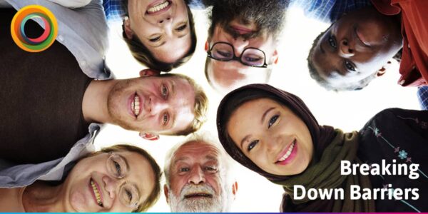 Mixed group of people, different ages, genders and skin tones all looking down at the camera and smiling