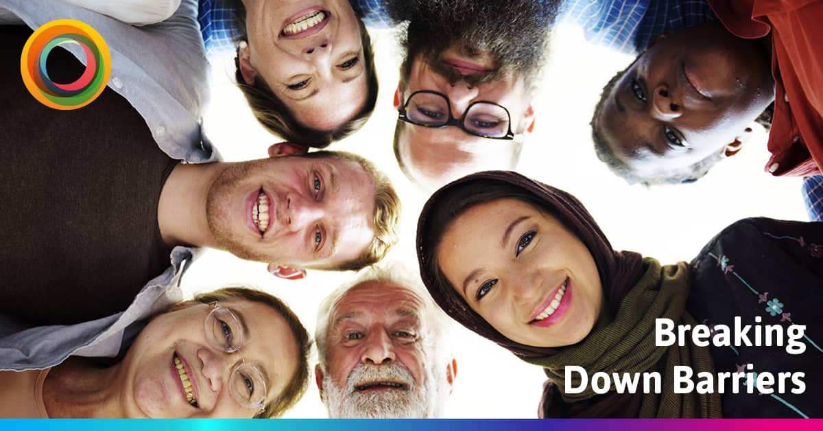 Mixed group of people, different ages, genders and skin tones all looking down at the camera and smiling