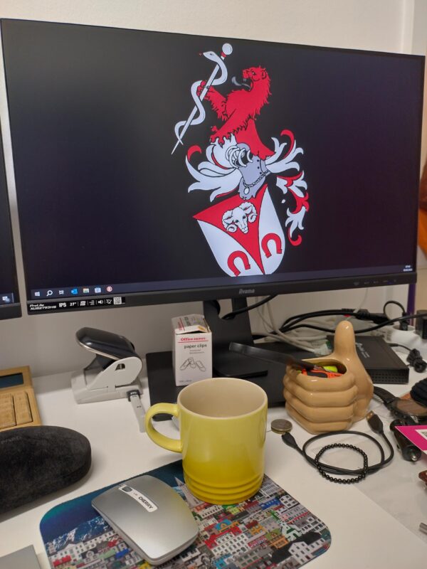 mobile health nurse's work desk with a monitor, yellow mug and a mouse