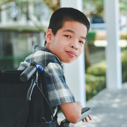 Boy in a wheelchair looking back over his shoulder